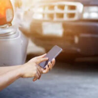 Person using his phone to call after a car accident