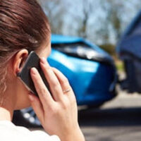 Woman calling by phone after a car accident
