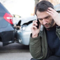 Man talking on his phone after a car crash