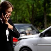 Women talking on her phone after suffering a car accident