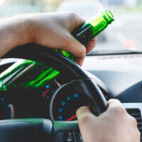 Man driving while drinking beer