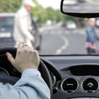 Car waiting for pedestrian to pass
