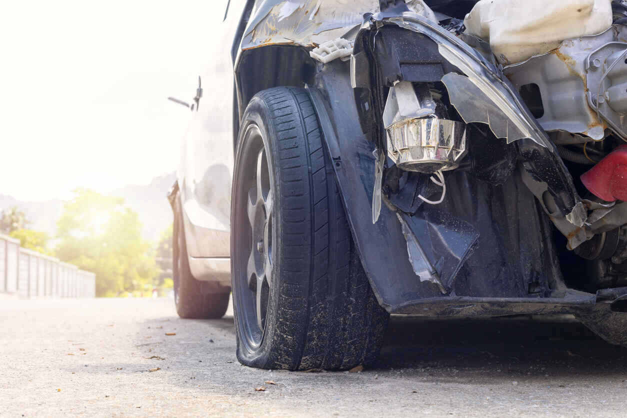 Heavily damaged car with a flat tire after a collision, for a Fremont car accident lawyer.