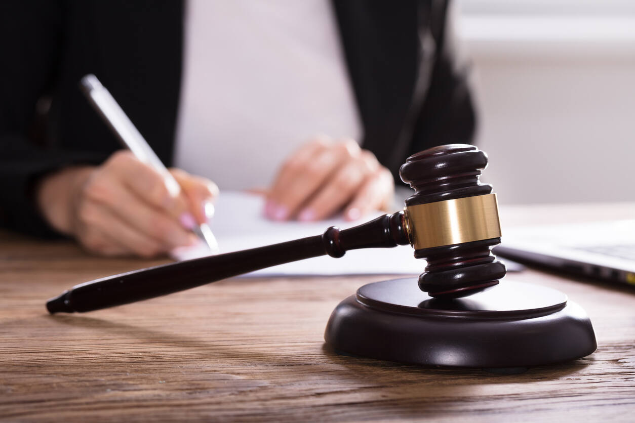 Los Gatos injury lawyer writing legal document and lawyer gavel on the table.