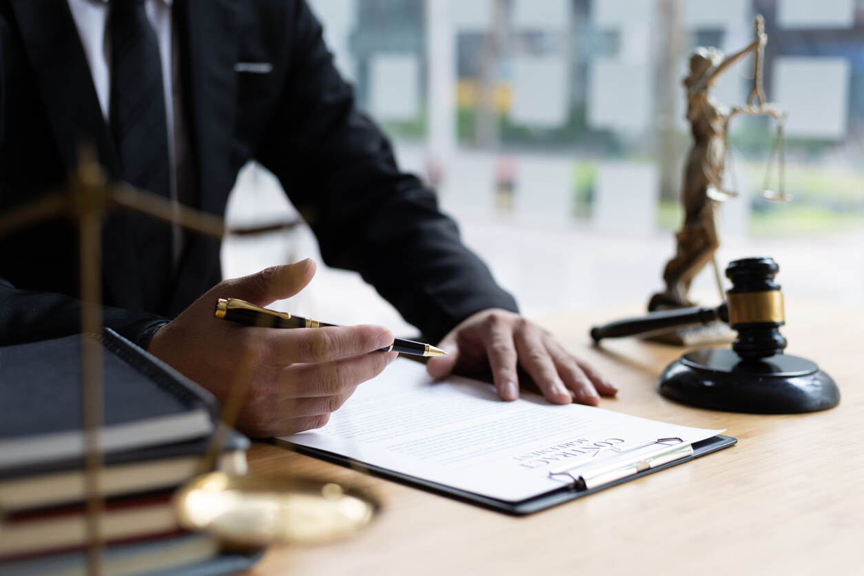A lawyer reviewing documents, with a gavel and scales of justice on the table, symbolizing personal injury legal work at campbell.