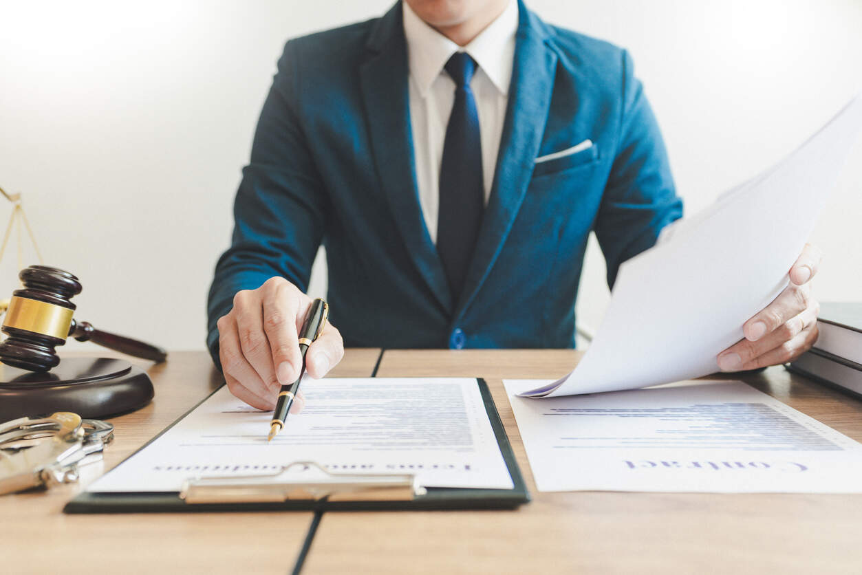 Attorney in a blue suit working on legal papers with a gavel and law books, representing a personal injury attorney's office at palo alto.