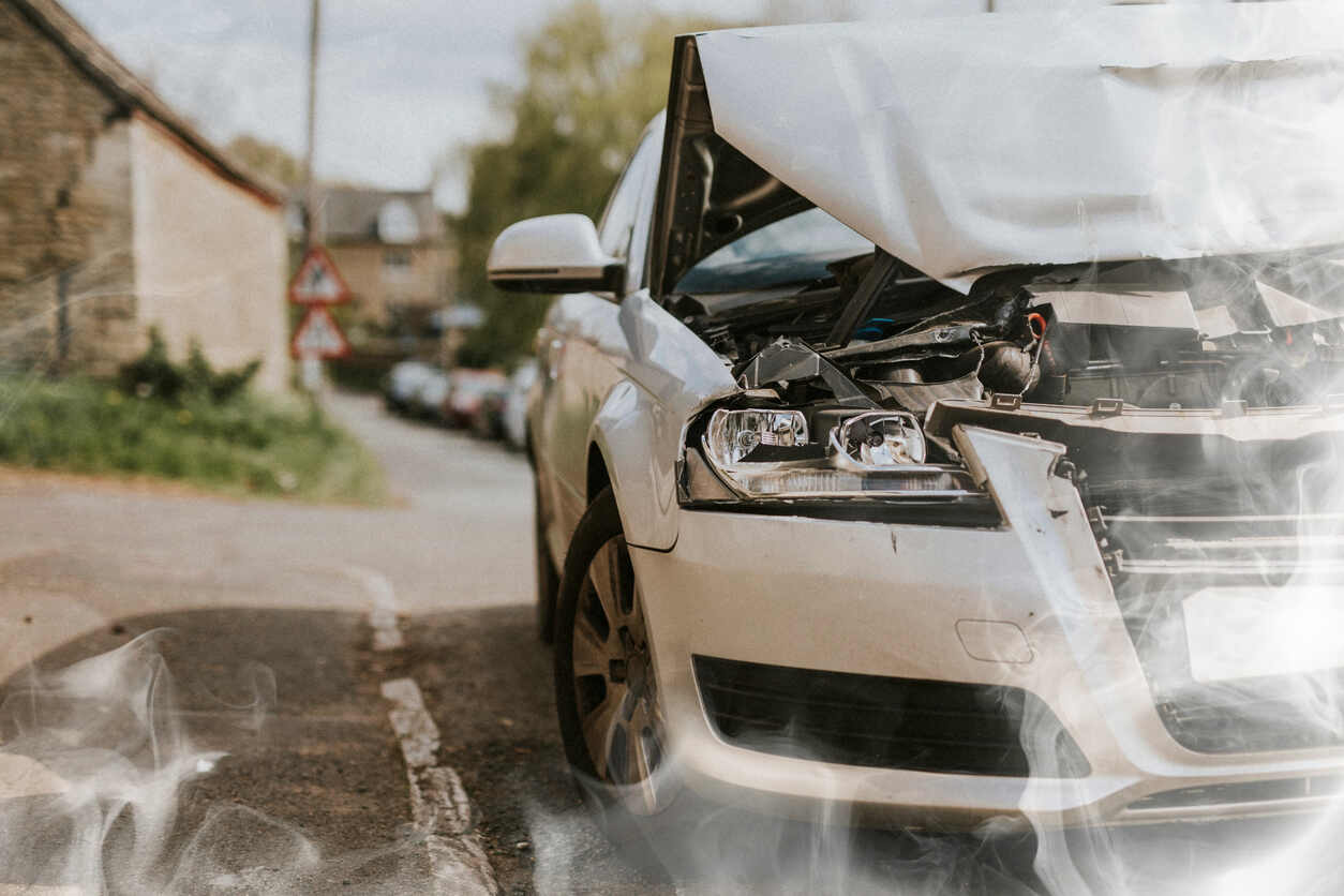 Damaged rental car with crumpled hood and smoke after an accident, for a San Jose rental car accident lawyer